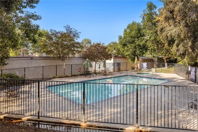 a view of a swimming pool with a patio and a yard