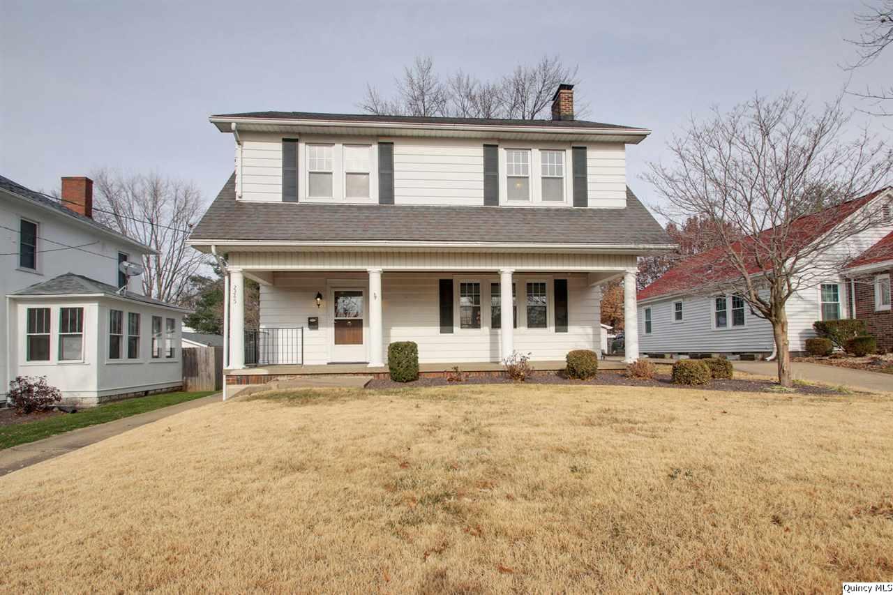 a front view of a house with yard and parking