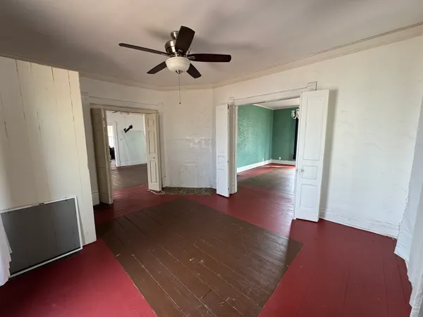 a view of a livingroom with wooden floor and a ceiling fan