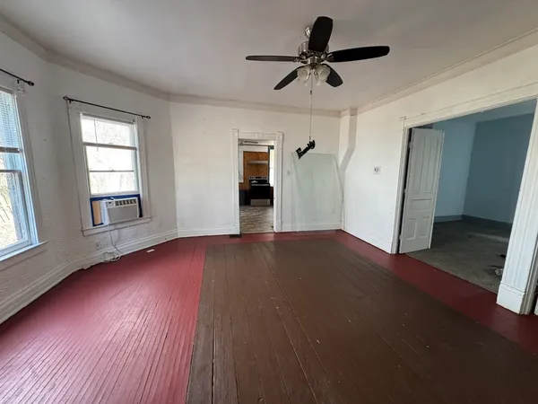 a view of empty room with wooden floor and window