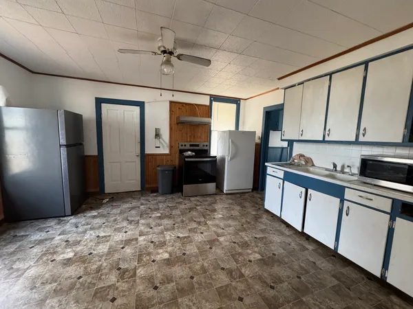 a kitchen with stainless steel appliances granite countertop a refrigerator and a stove top oven