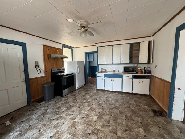 a kitchen with granite countertop a refrigerator stove top oven and sink