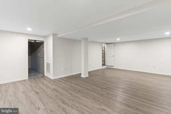 a view of an empty room with wooden floor