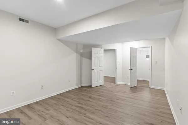 a view of an empty room with wooden floor