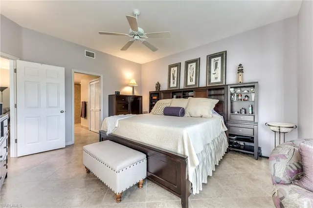 a bedroom with a large bed and a chandelier