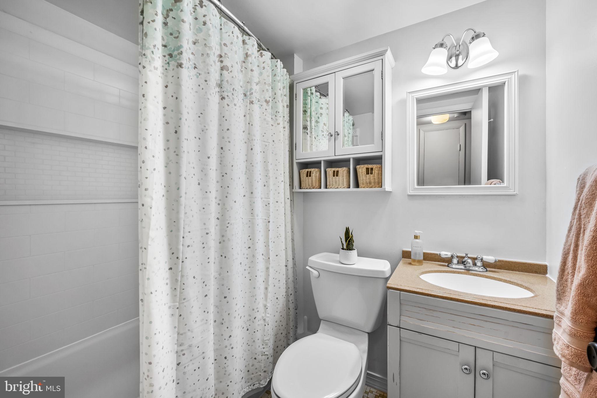 12 Cardor Court, Unit 100 Nottingham, MD 21236 - Photo 15 of 21 a bathroom with a sink a toilet and shower curtain