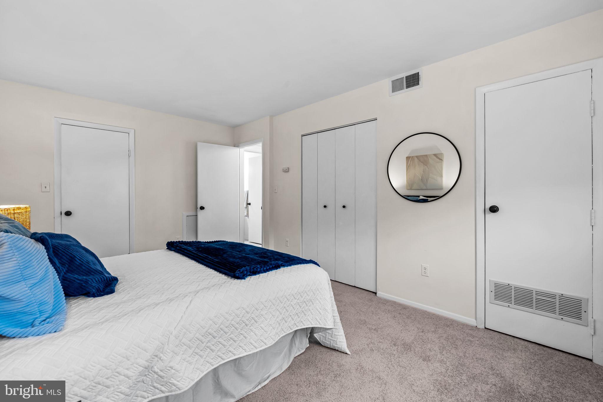 12 Cardor Court, Unit 100 Nottingham, MD 21236 - Photo 17 of 21 a bedroom with a bed and a mirror