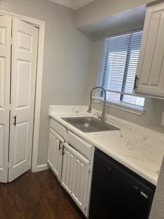 a kitchen with a sink cabinets and a window
