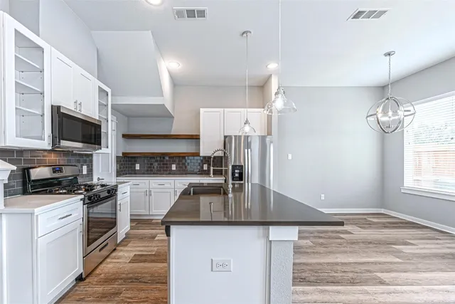 a kitchen with kitchen island a sink stainless steel appliances and window