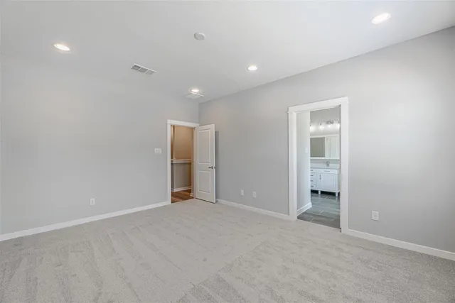 an empty room with closet and entrance to other room