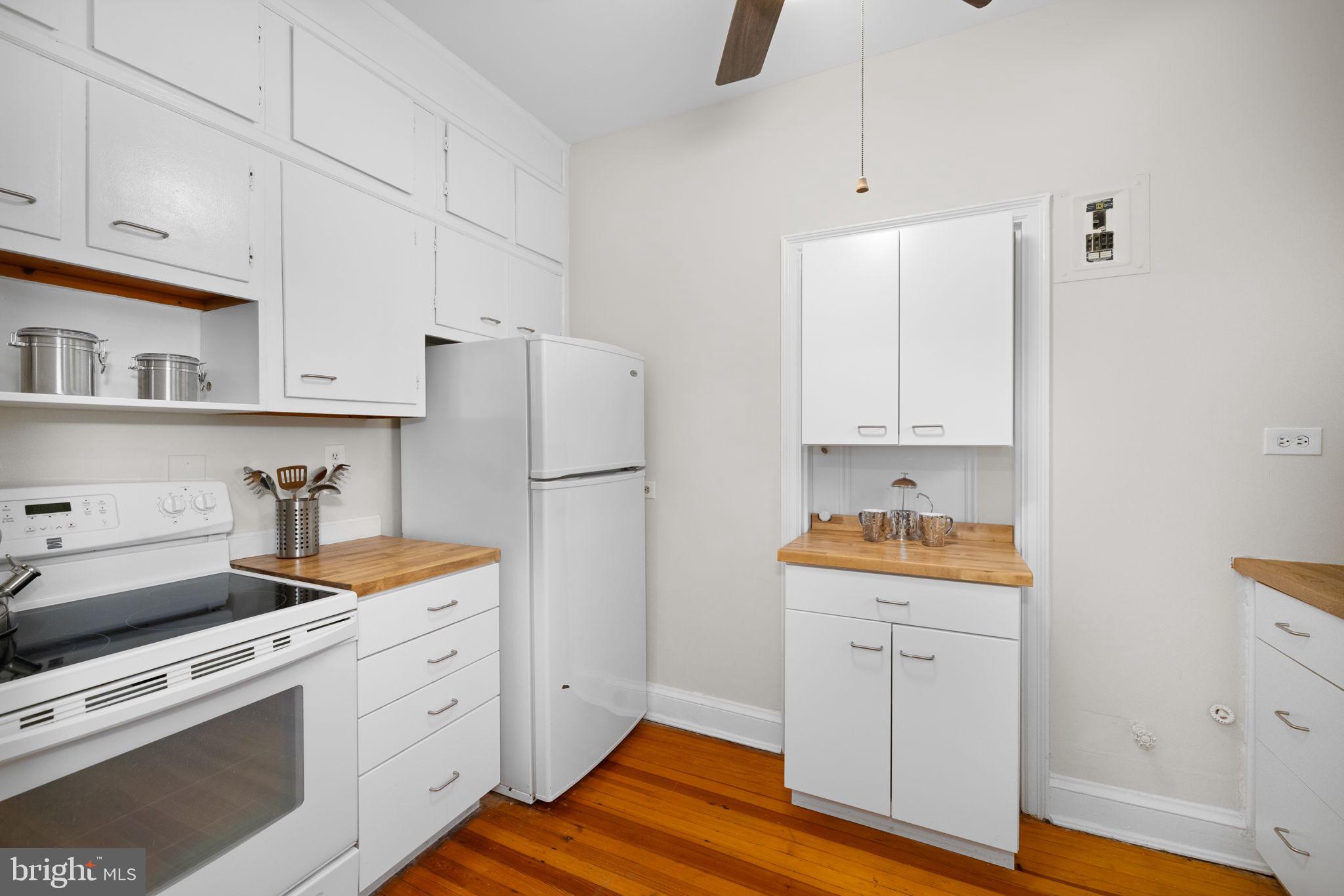 3900 Connecticut Avenue Northwest, Unit 202G Washington, DC 20008 - Photo 10 of 21 a kitchen with stainless steel appliances white cabinets and wooden floor