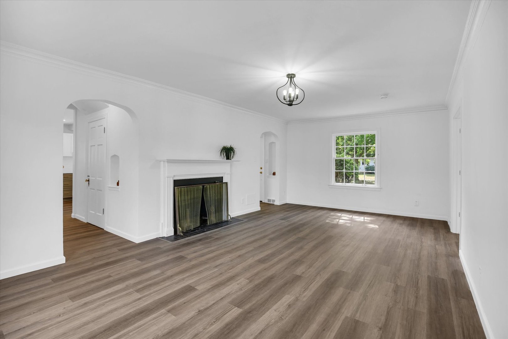 1212 West Healey Street Champaign, IL 61821 - Photo 12 of 63 an empty room with wooden floor a fireplace and windows