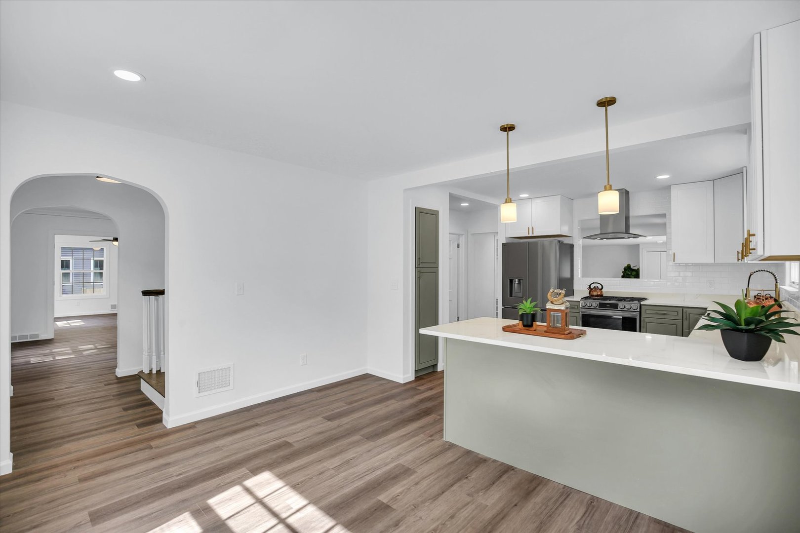 1212 West Healey Street Champaign, IL 61821 - Photo 15 of 63 a view of a kitchen with kitchen island a wooden floor stainless steel appliances and a window