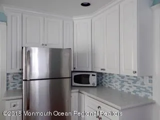 a large kitchen with kitchen island a counter top space a sink and appliances