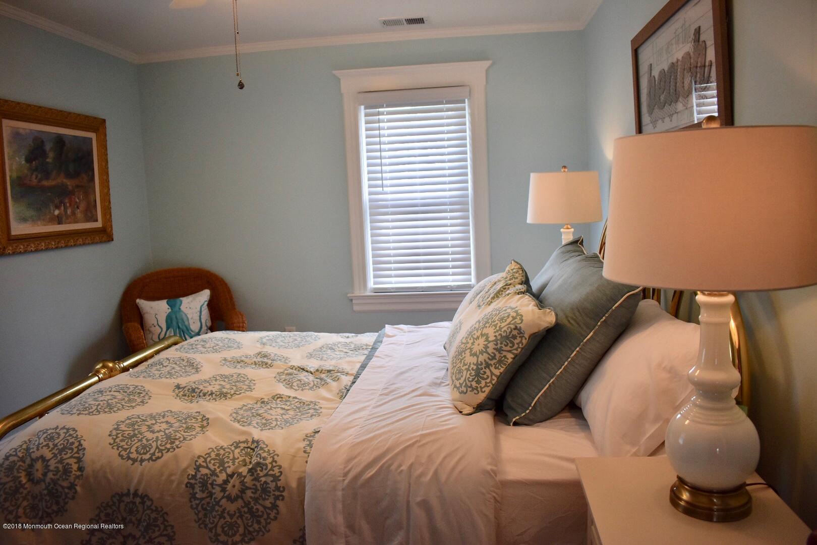 422 Worthington Avenue, Unit SUMMER 2026 Spring Lake, NJ 07762 - Photo 35 of 57 a bedroom with a bed and wall painting