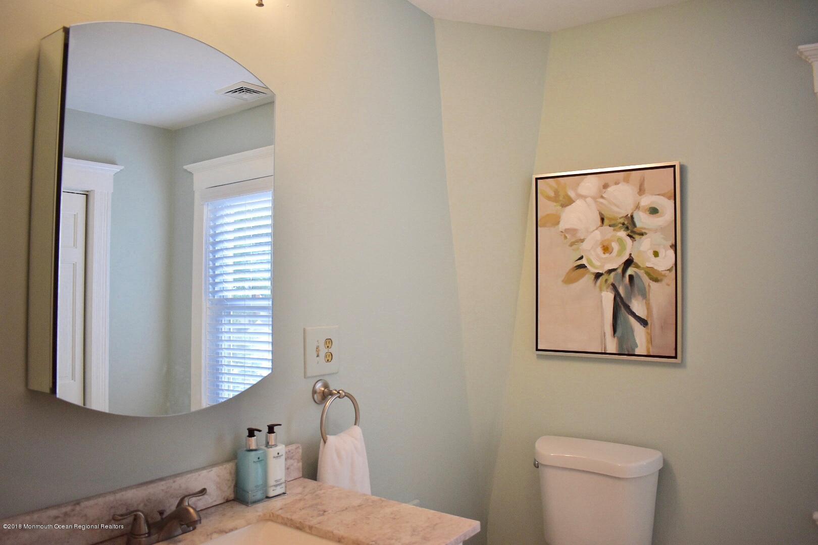 422 Worthington Avenue, Unit SUMMER 2026 Spring Lake, NJ 07762 - Photo 40 of 57 a bathroom with a toilet and a picture on the wall