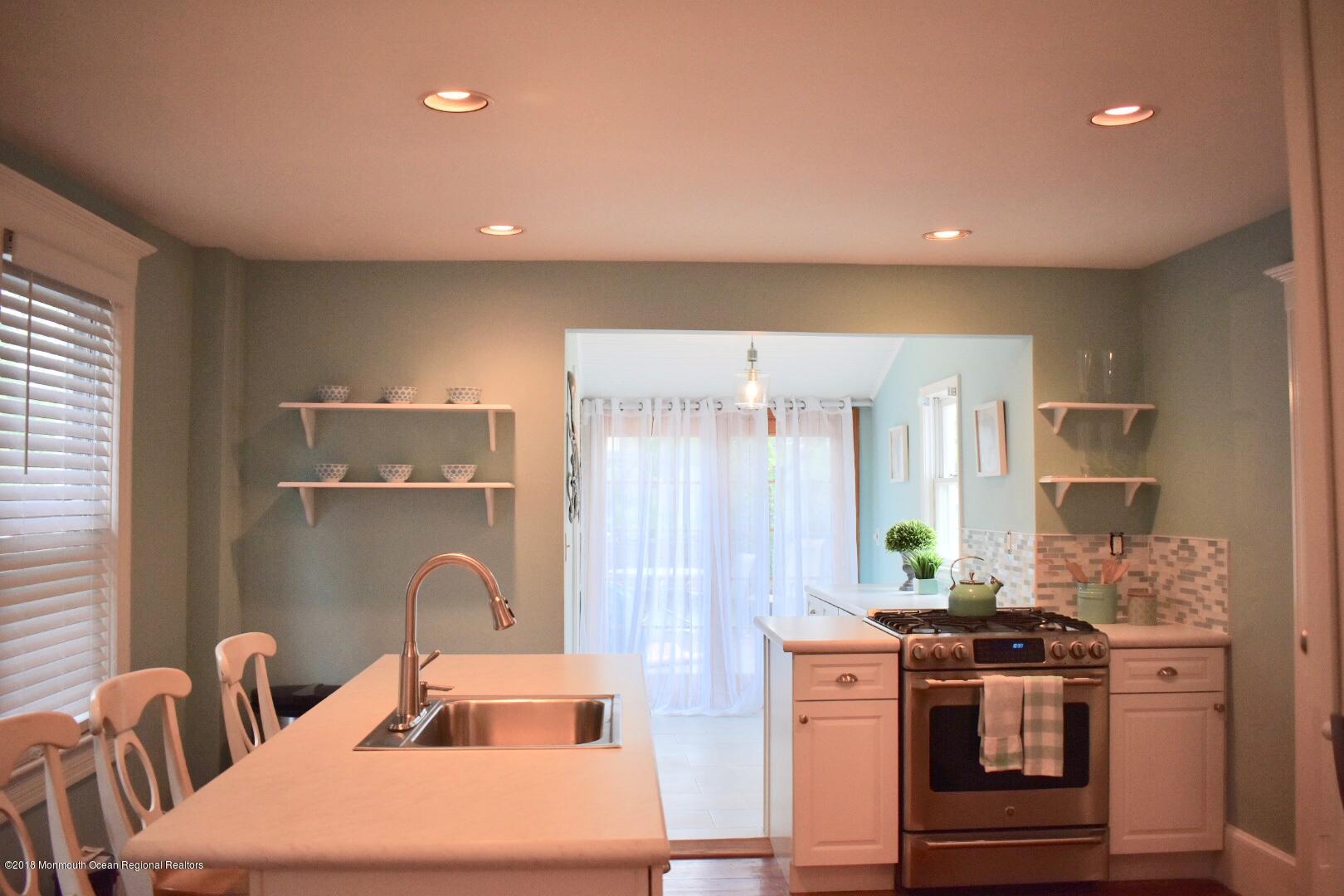 422 Worthington Avenue, Unit SUMMER 2026 Spring Lake, NJ 07762 - Photo 42 of 57 a kitchen with kitchen island a stove a sink and a refrigerator