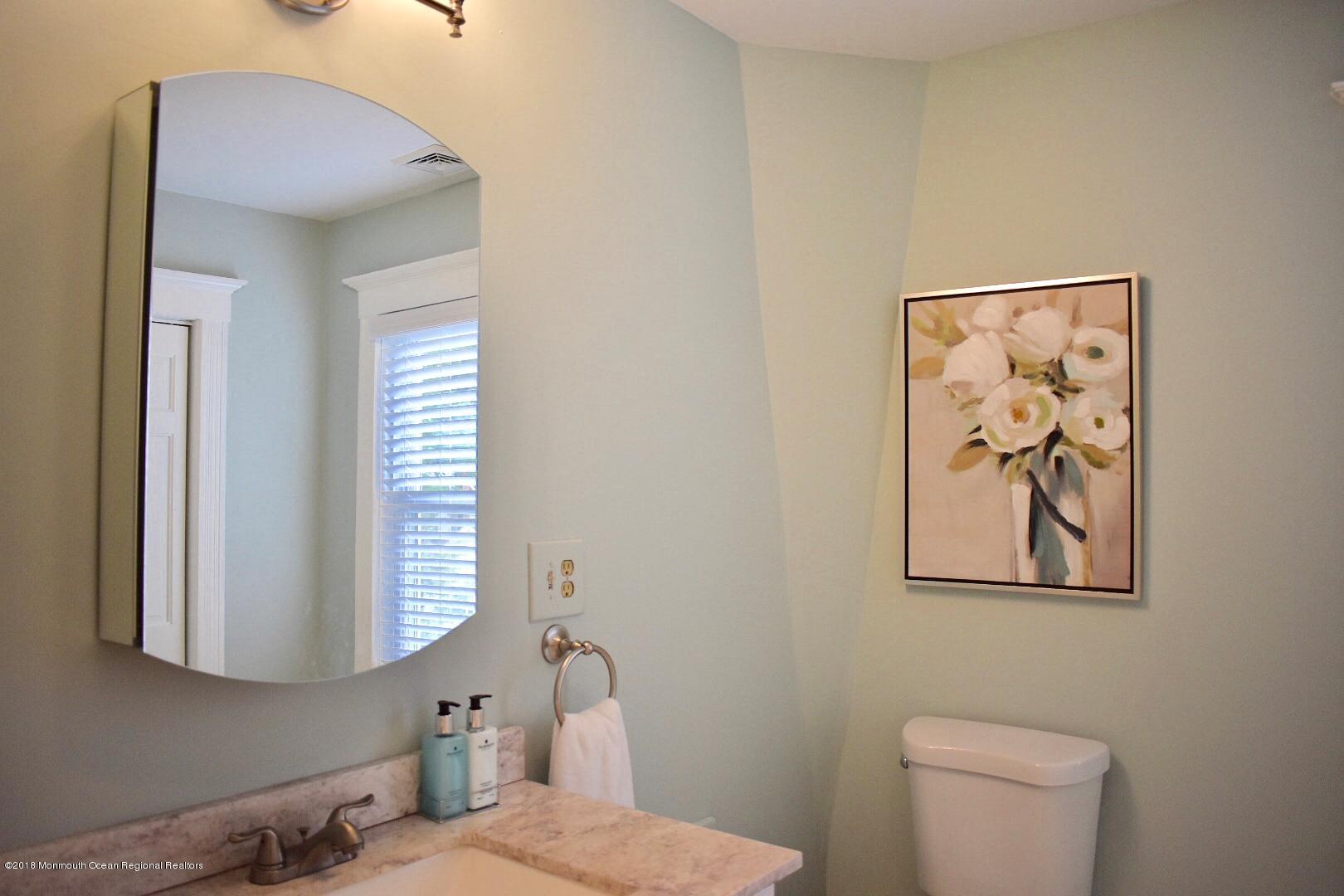 422 Worthington Avenue, Unit SUMMER 2026 Spring Lake, NJ 07762 - Photo 43 of 57 a bathroom with a toilet and a picture on the wall