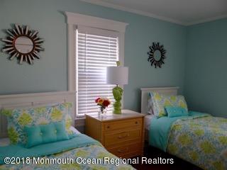 422 Worthington Avenue, Unit SUMMER 2026 Spring Lake, NJ 07762 - Photo 48 of 57 a bed sitting in a bedroom next to a window