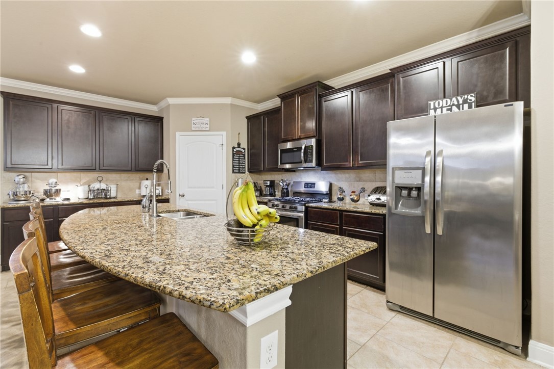 8826 Virginia Rye San Antonio, TX 78254 - Photo 14 of 40 a kitchen with stainless steel appliances granite countertop a sink a stove and a refrigerator
