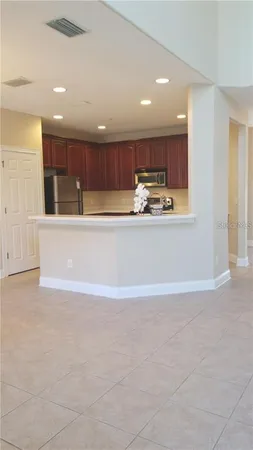 a view of kitchen with kitchen island and stainless steel appliances