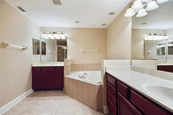a spacious bathroom with a tub sink and mirror