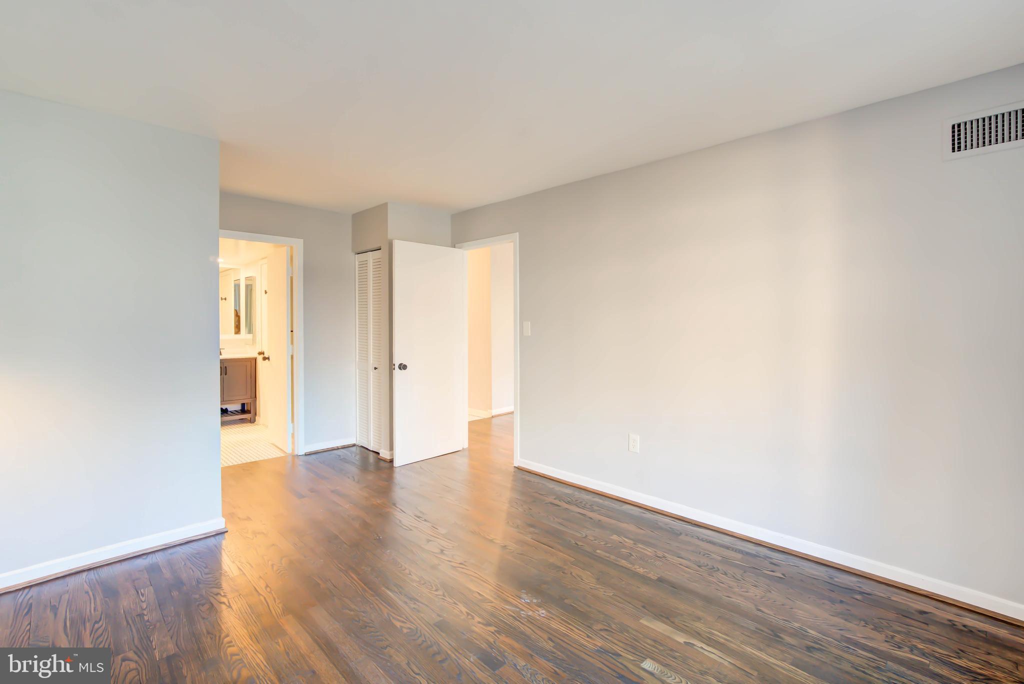 2111 Wisconsin Avenue Northwest, Unit 302 Washington, DC 20007 - Photo 14 of 23 a view of an empty room with wooden floor and a window