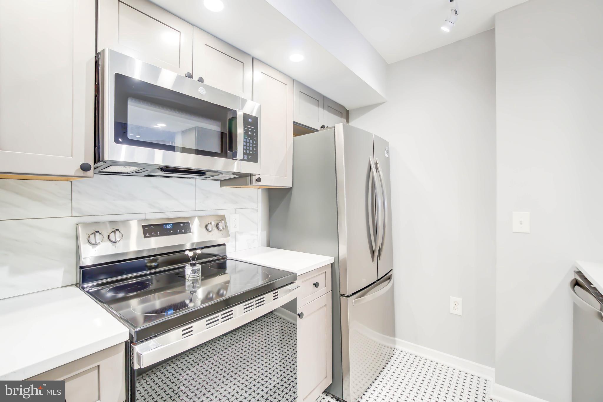 2111 Wisconsin Avenue Northwest, Unit 302 Washington, DC 20007 - Photo 4 of 23 a kitchen with stainless steel appliances a microwave a stove and cabinets