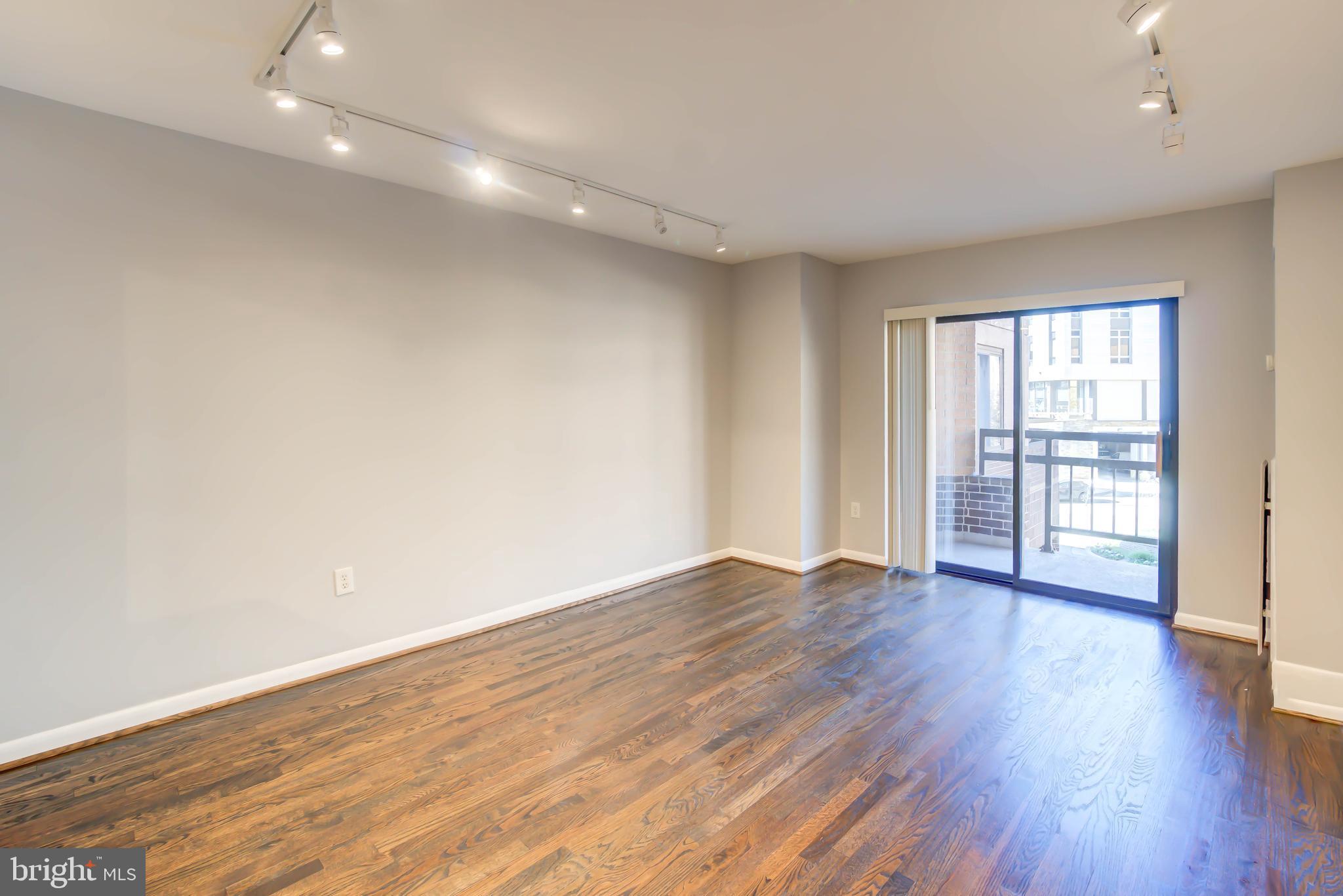 2111 Wisconsin Avenue Northwest, Unit 302 Washington, DC 20007 - Photo 6 of 23 wooden floor in an empty room with a window