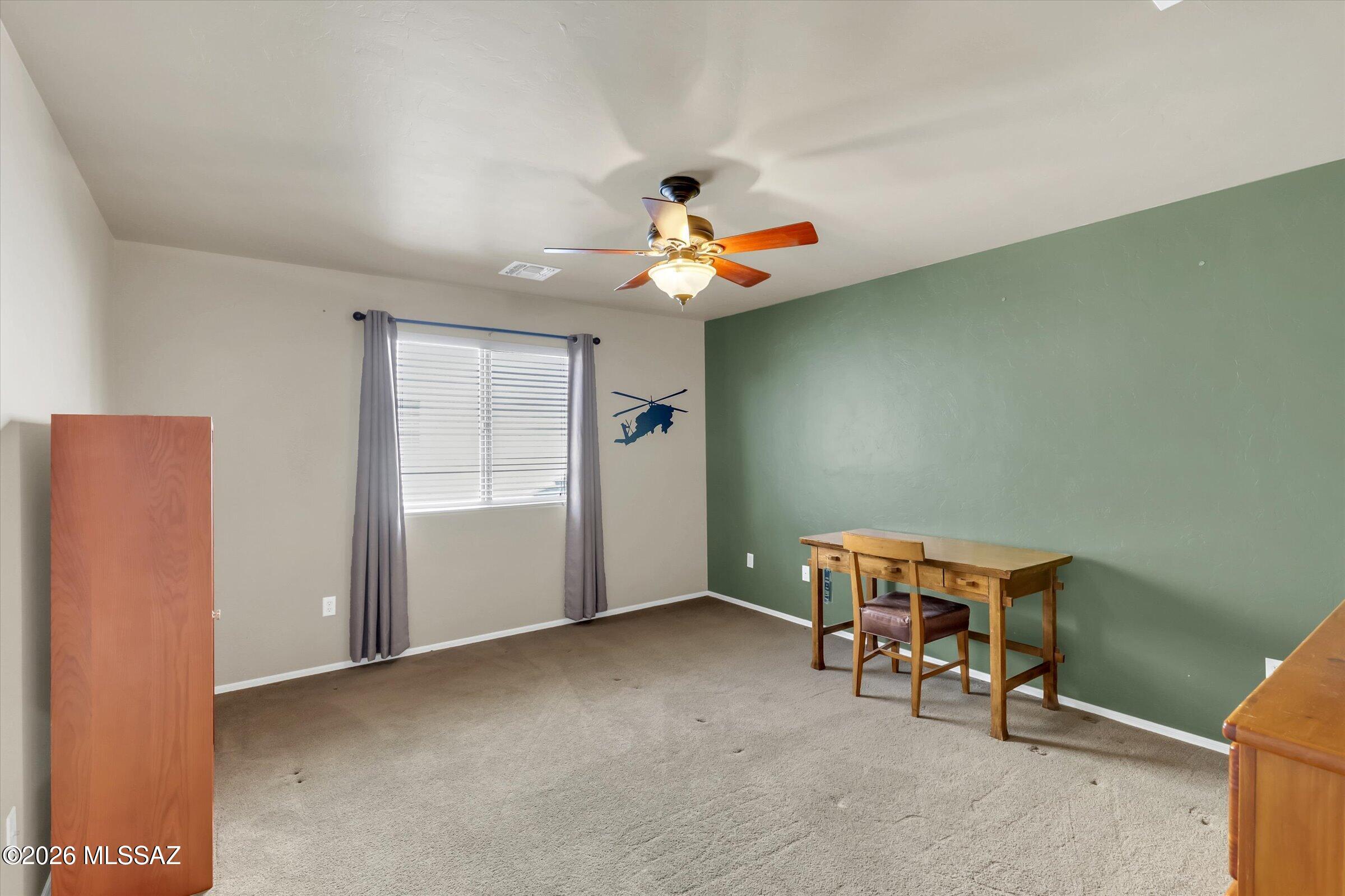 6095 South Jakemp Trail Tucson, AZ 85747 - Photo 32 of 52 a view of livingroom with a ceiling fan and a window