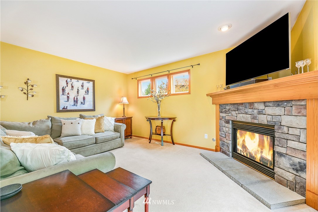 1117 184th Place Southeast Bothell, WA 98012 - Photo 14 of 40 a living room with furniture a flat screen tv and a fireplace