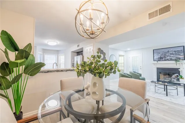 a view of a dining room with furniture a potted plant and wooden floor