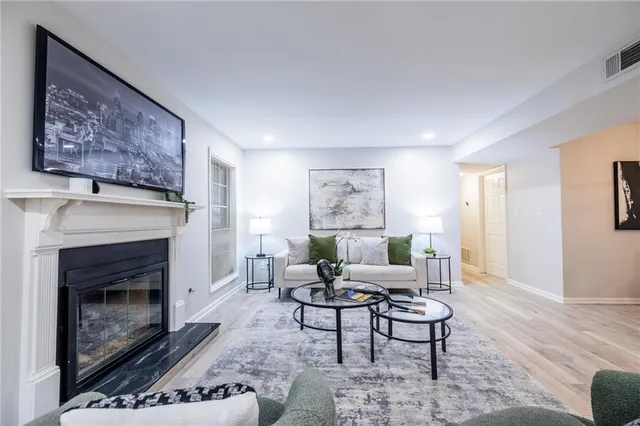 a living room with furniture a flat screen tv and a fireplace