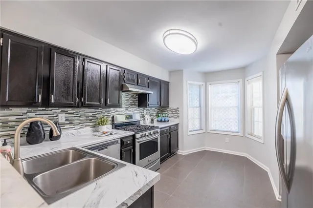 a kitchen that has a sink and a stove top oven