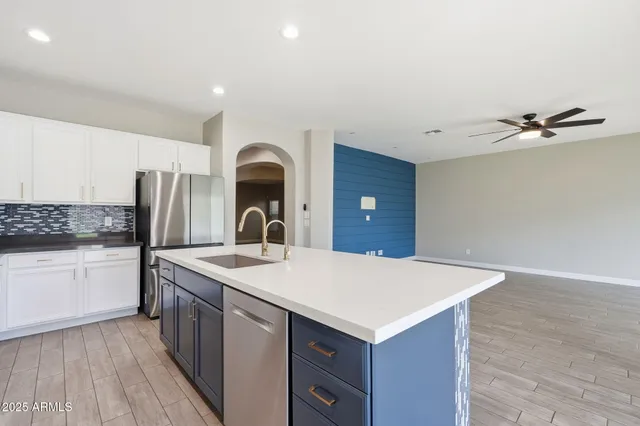 a kitchen with a sink a stove cabinets and wooden floor