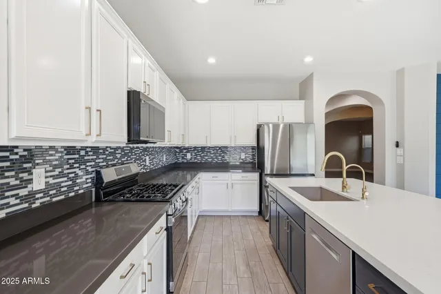 a kitchen with stainless steel appliances granite countertop a sink stove and refrigerator