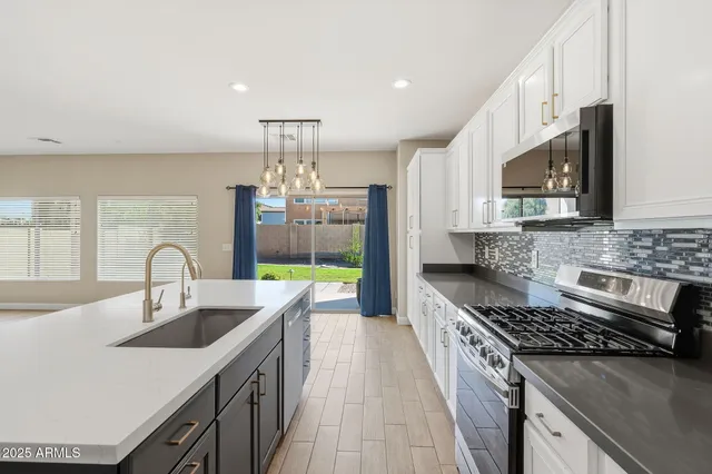 a kitchen with kitchen island granite countertop a sink stove top oven and cabinets
