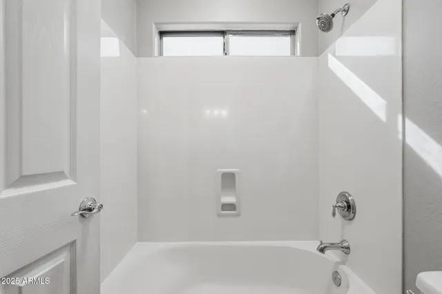 a bath room with a sink a mirror and a bath tub