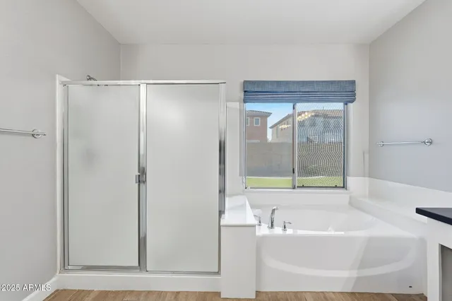 a bathroom with a granite countertop tub a sink and a large mirror