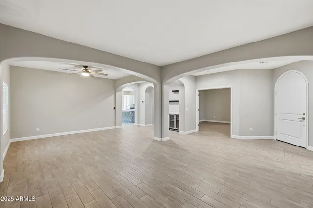 a view of a big room with wooden floor and windows
