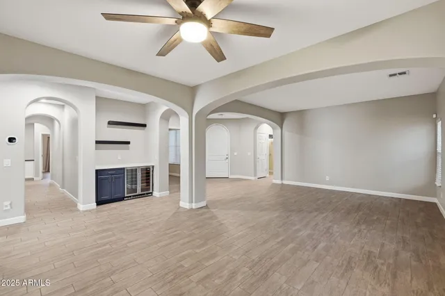 a view of an empty room with a window and a kitchen