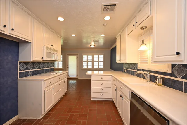 a kitchen with stainless steel appliances a sink stove and cabinets