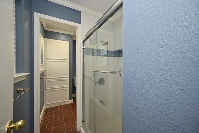 a bathroom with a shower and a glass door