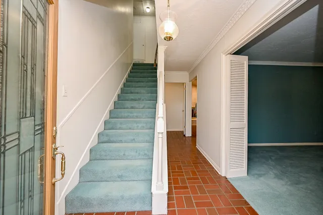 a view of a hallway with wooden floor and staircase