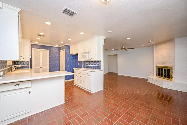 a kitchen with stainless steel appliances kitchen island granite countertop a stove top oven a sink a counter top space and cabinets