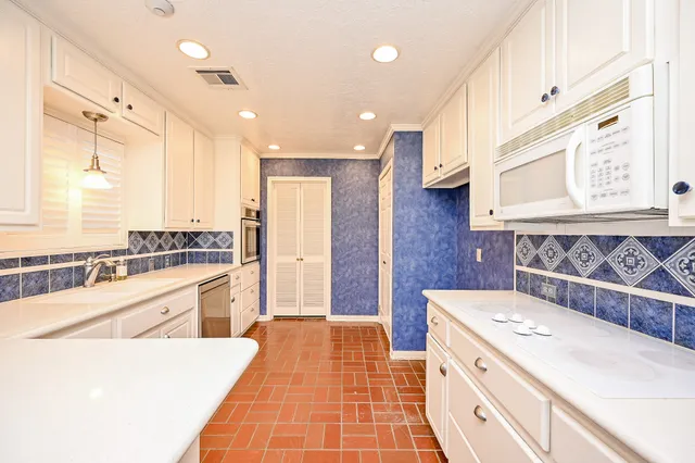 a large kitchen with stainless steel appliances granite countertop a sink and cabinets
