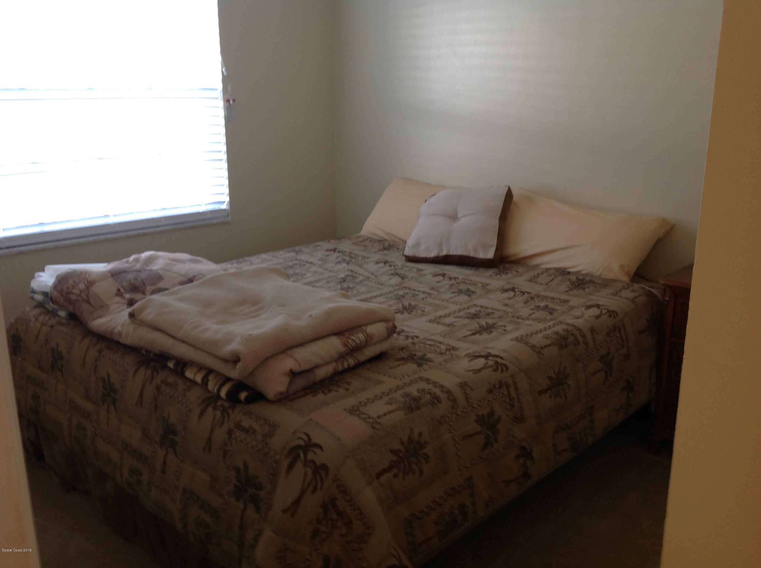 2819 Lancaster Road Melbourne, FL 32935 - Photo 8 of 24 a bed sitting in a bedroom next to a window