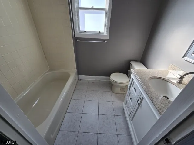a bathroom with a granite countertop sink toilet and bathtub