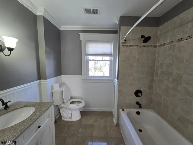 a bathroom with a granite countertop sink a toilet and shower