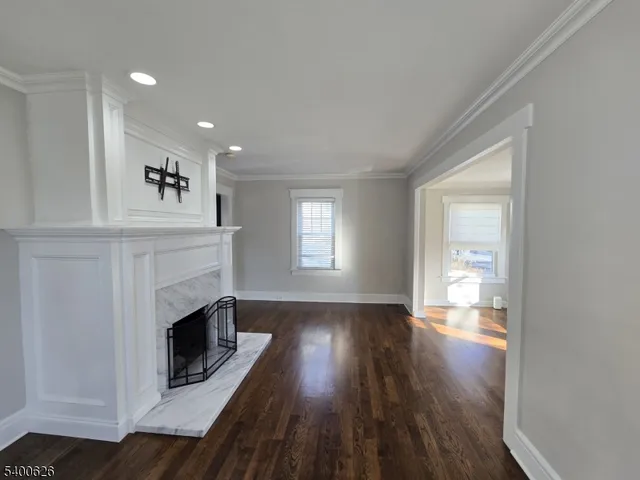 a view of a livingroom with wooden floor and a fireplace